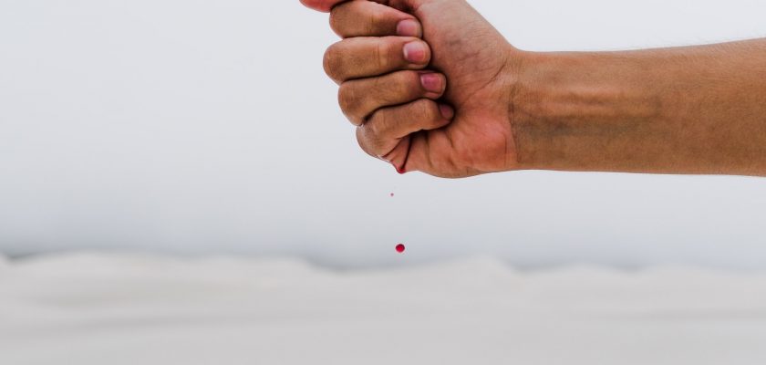 blood drop falling from persons hand