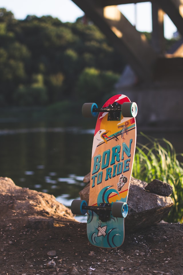 skateboard standing beside river